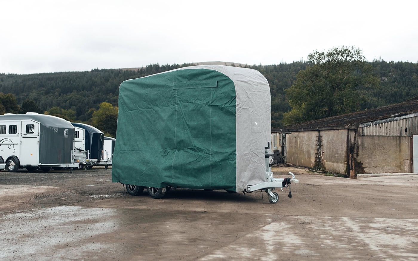 A picture of a Cheval Horsebox with a bespoke fit outdoor cover in green and grey.