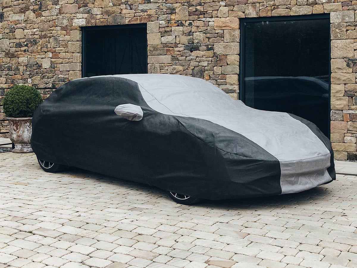 A bespoke fit outdoor car cover in black and grey on a Porsche.