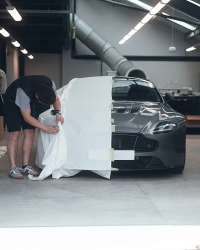 A picture showing a designer tailoring a cloth pattern for a car cover.