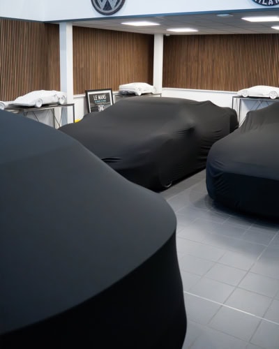 An image of multiple cars in storage with Indoor Lite covers on.