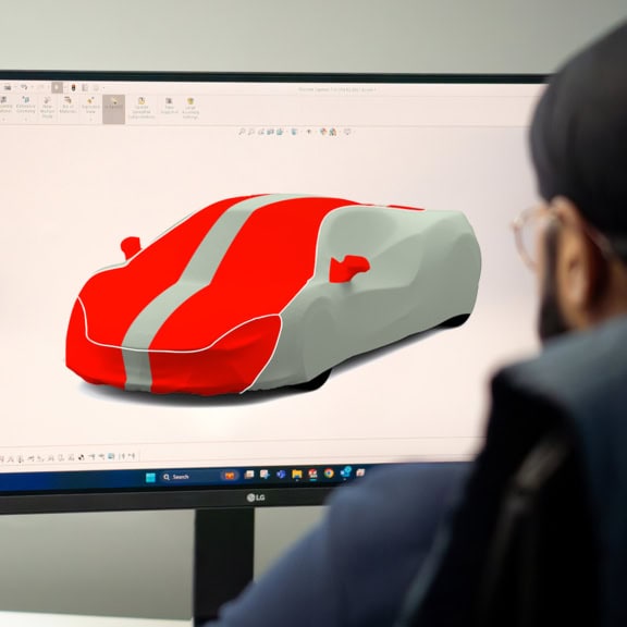 A picture of a computer screen and 3D designer working on some colour schemes for a Mclaren Indoor Plus car cover.