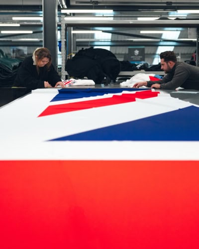 A picture of our team working on a printed Indoor Reveal with a Union Jack Flag.