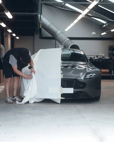 A picture of a designer tailoring patterning cloth for a car cover pattern.