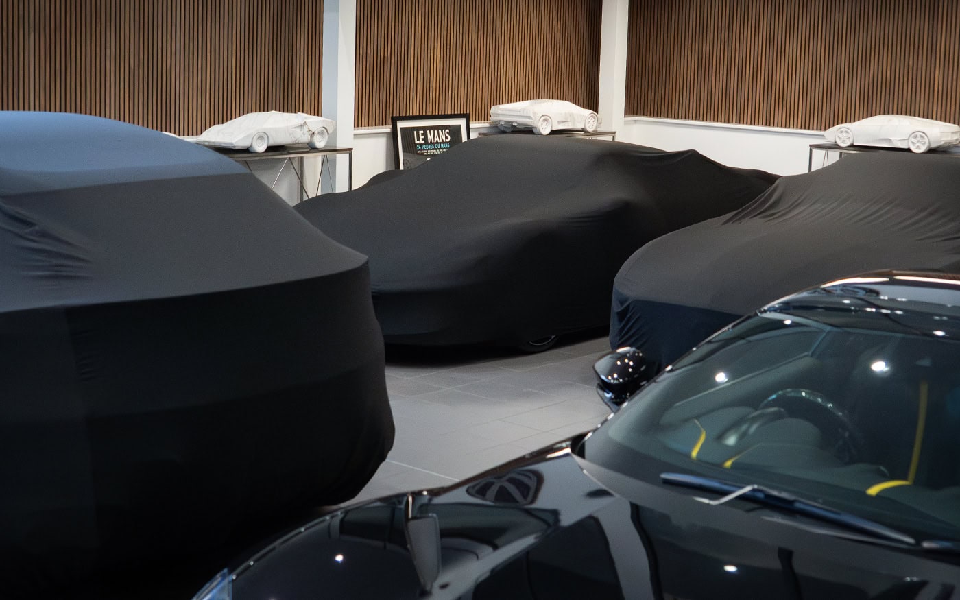 Multiple cars all in different sizes with universal fitting car covers on.