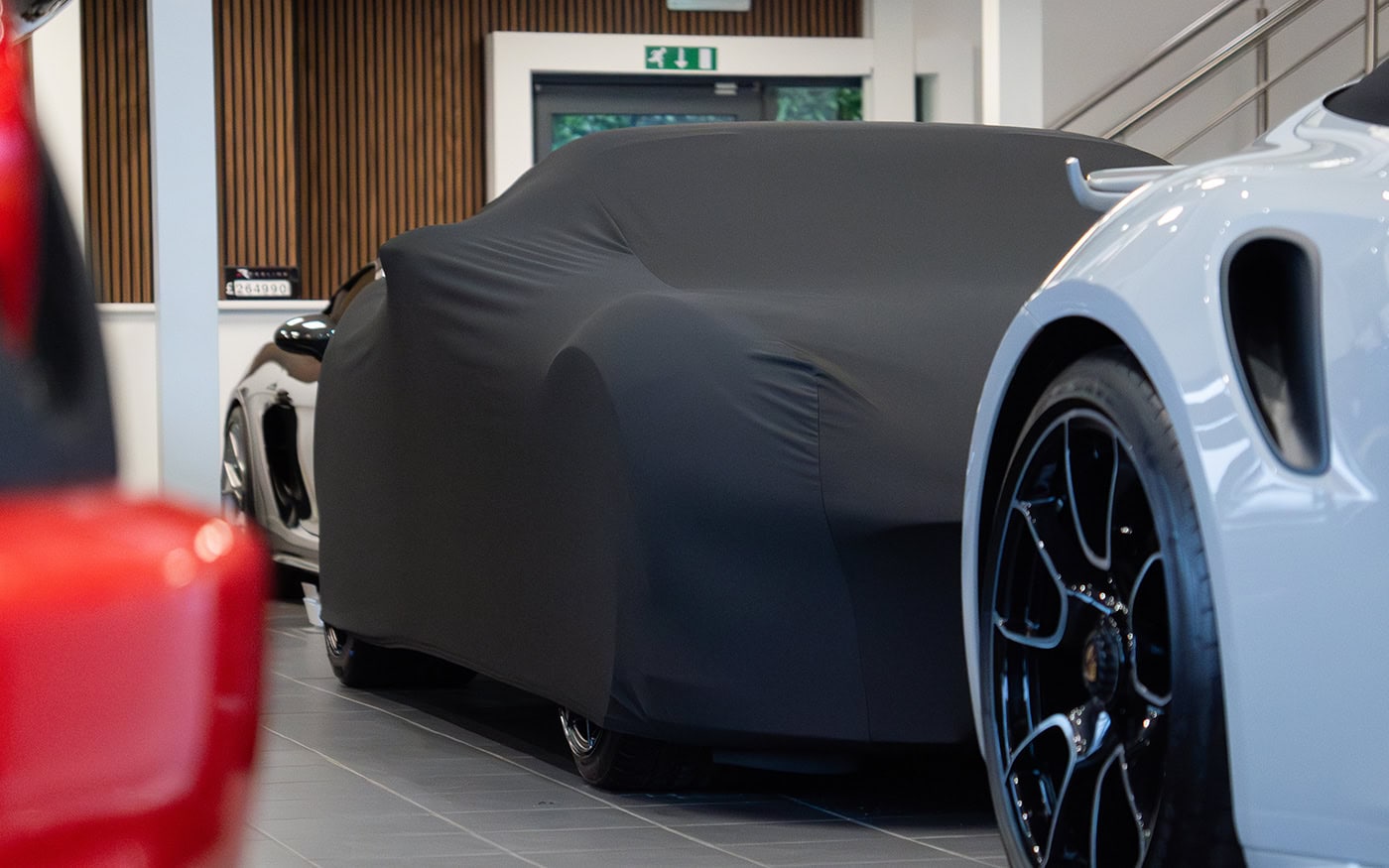 A car in a showroom with a universal fitting cover on.