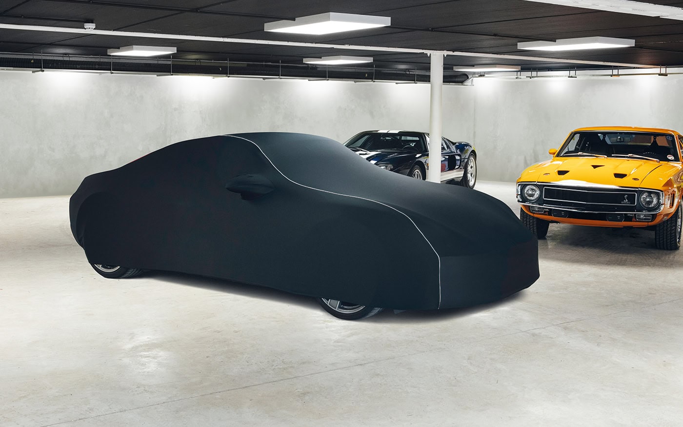A Porsche in a garage with a bespoke fit indoor cover.