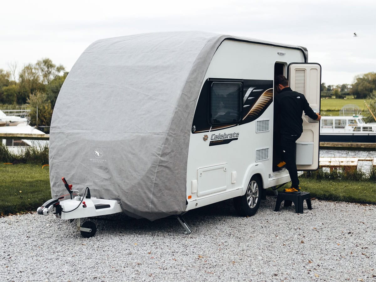 A picture of someone accessing the door whilst the Caravan Roof Cover is on.