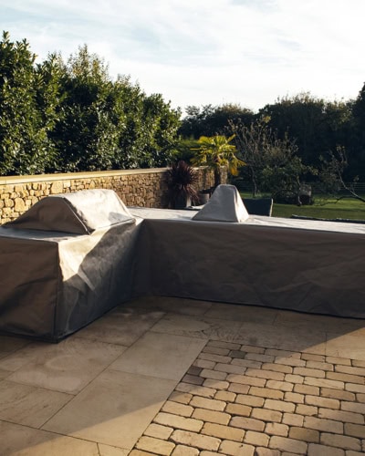 A custom outdoor kitchen cover on a bespoke bbq, worktop and sink set up.
